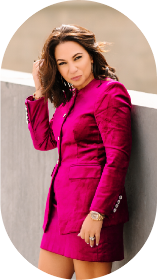 woman wearing a pink suit while leaning on a wall